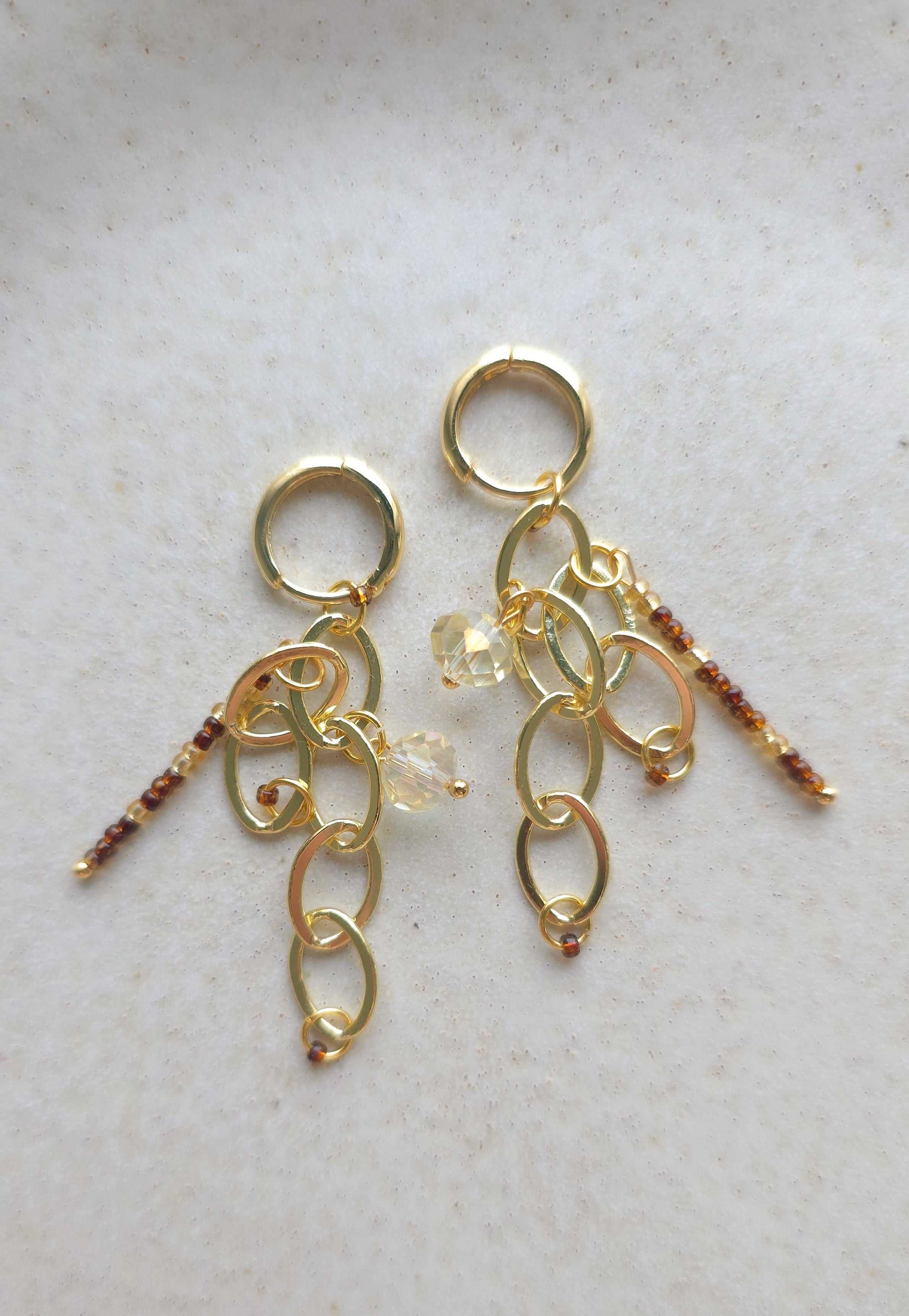 Auskari zelta krāsām no ķēdītēm un spožām pērlītēm. Ļoti vieglas un elegantas rotas sievietēm.