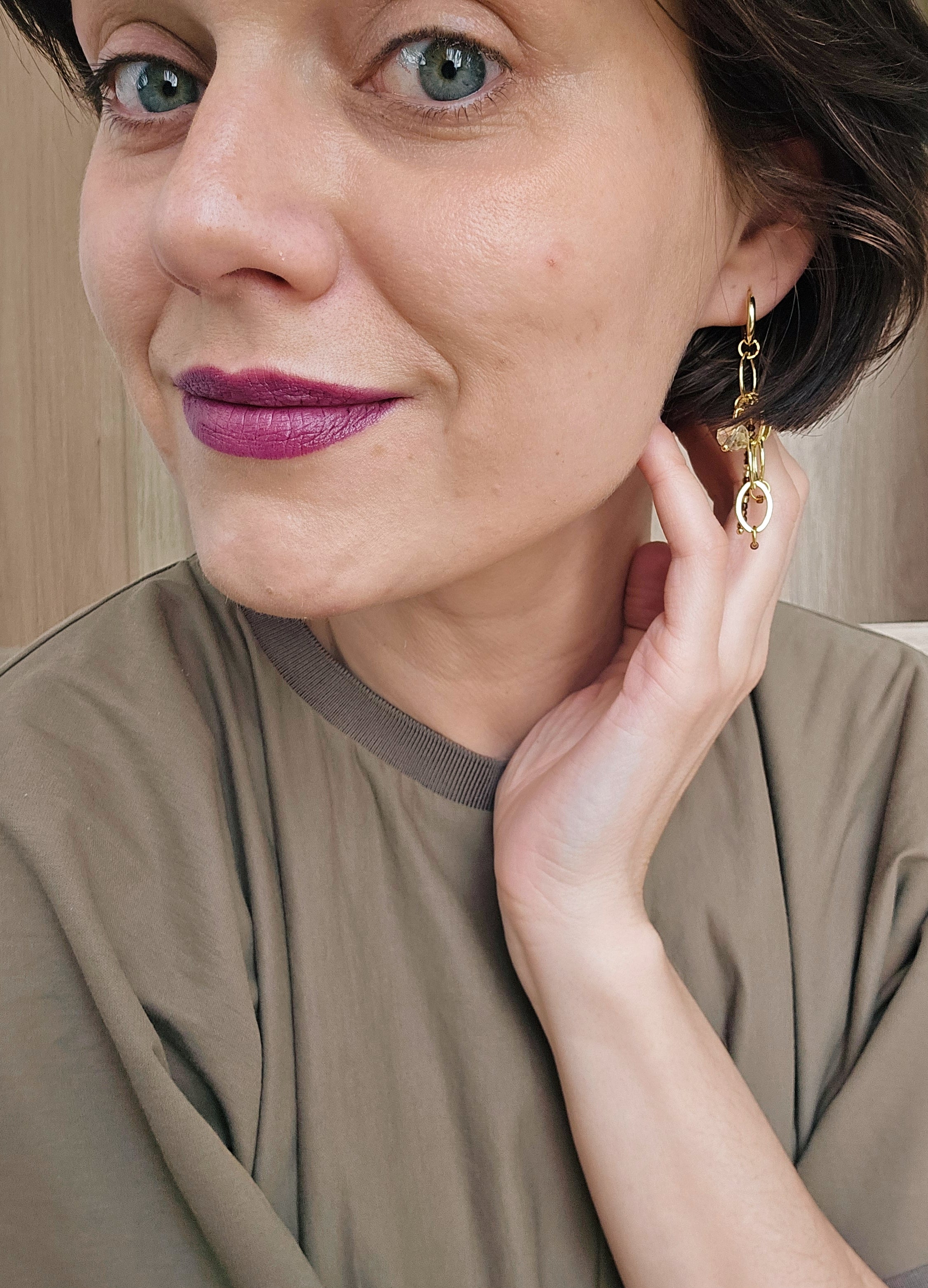 Wome  in Coss dress and purple Kiko lipstick wearing shiny chain earrings