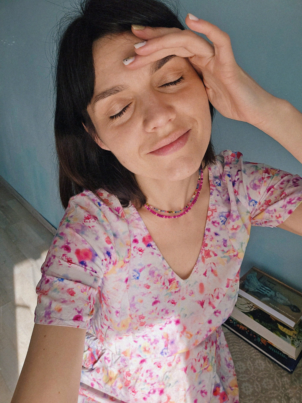 Woman in a colorful floral Esprit summer dress with bold pink necklace