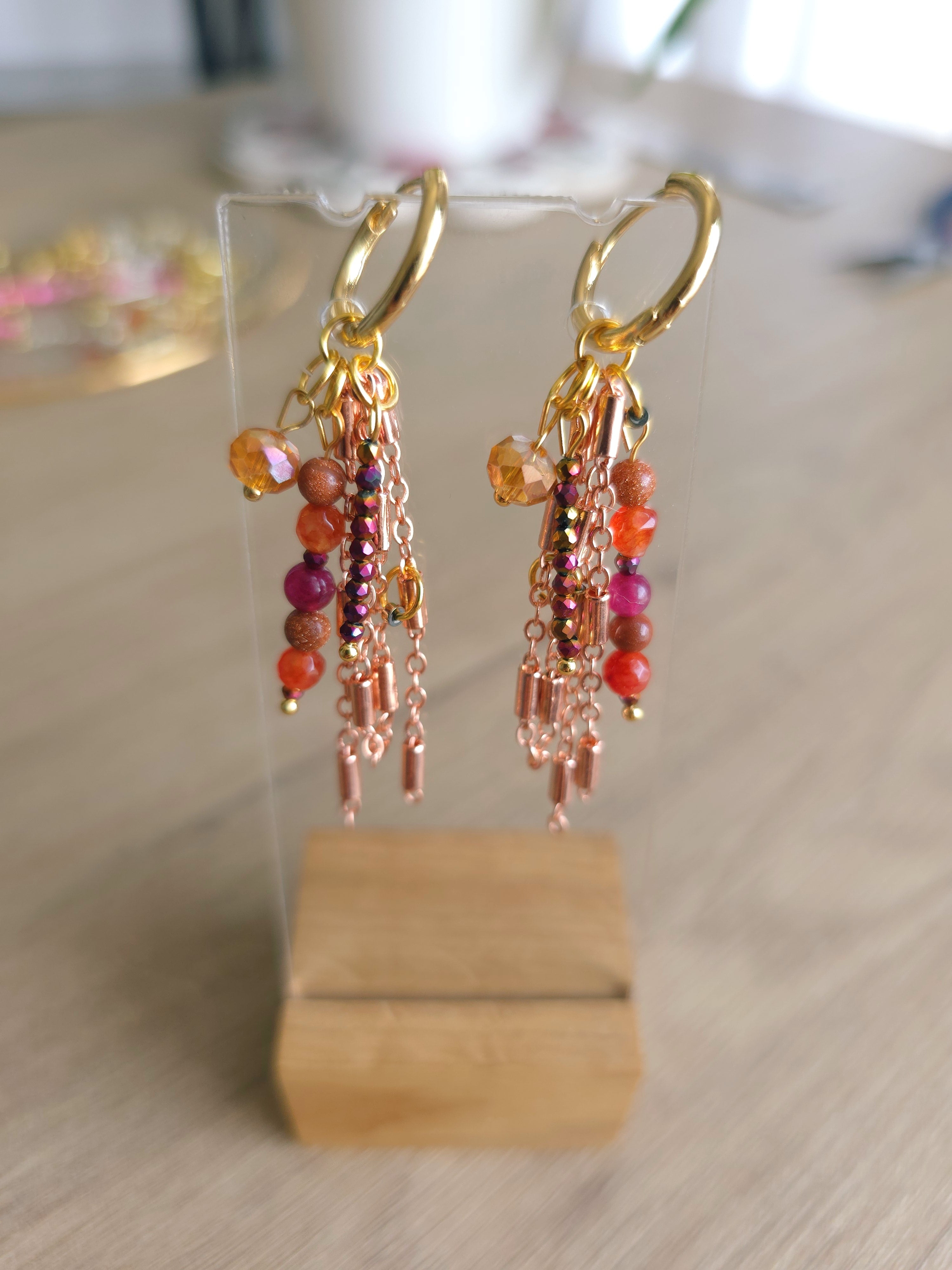 Pair of sparkling blushy earrings for women placed on beige table