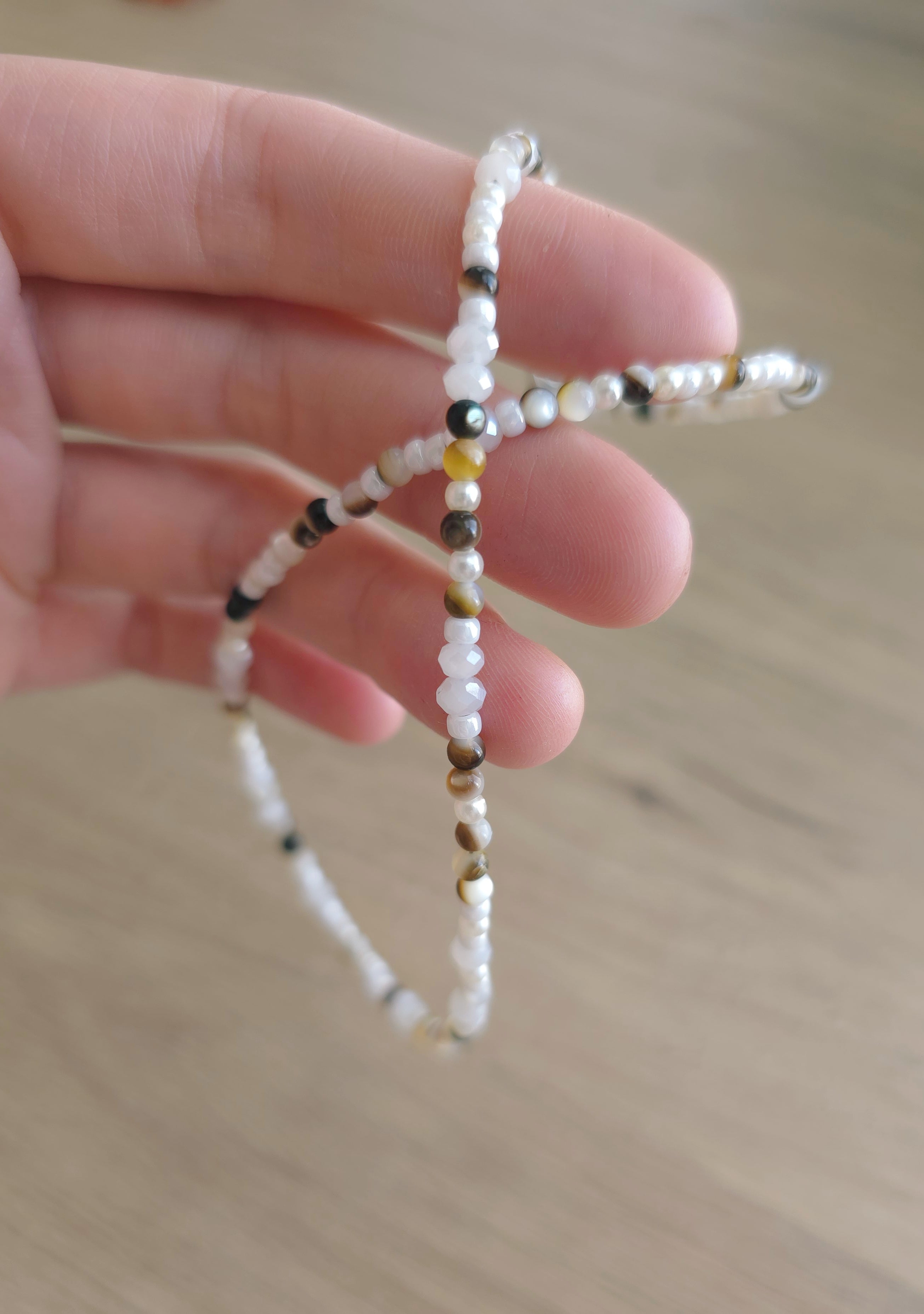 Balta kaklarota ar perlamutra brūniem akcentiem. 