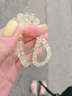Hand holding a beaded bracelet with a blurred background